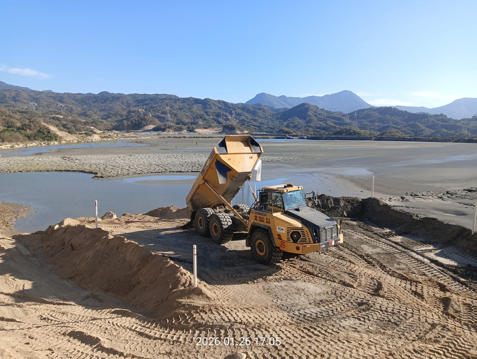 Excavadora y camión articulado trabajando en movimiento de tierra